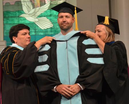 Bryan Carrier, acting dean of students receives his doctoral hood at summer commencement services at West Jackson Baptist Church. - Photo by Morris Abernathy