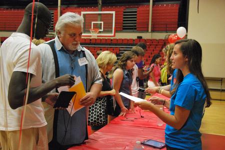 Erin Allen (right), junior social work major, talks with incoming freshman Lamin Sillah and Tim Purselley about residence life during new student move-in day. - Photo by Anne Richoux