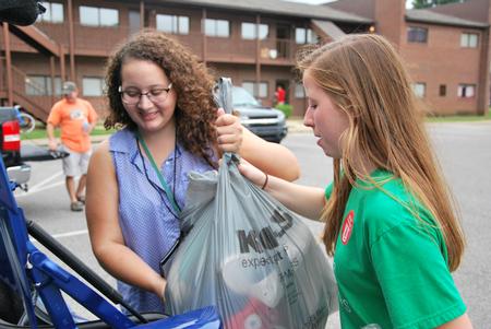 Heather Vidal (right), sophomore biology major, helps incoming freshman Vanessa Rivera move into her room on new student move-in day.  - Photo by Anne Richoux