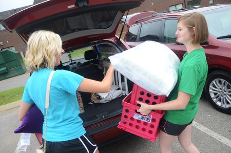 Emily Wood (Right), senior intercultural studies major, helps Bre Clendonin, freshman nursing major, move into her room during new student move-in day. - Photo by Matt McDaniel