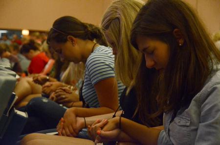 New students bow in prayer as faculty, staff, upperclassmen, and their families surround them and pray for them as they begin their time at Union. - Photo by Anne Richoux