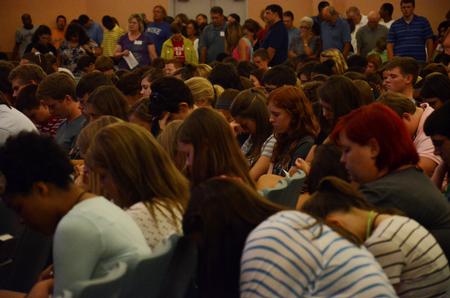 New students bow their heads as the president of the university, David S. Dockery, prays for them and their years at Union.  - Photo by Anne Richoux