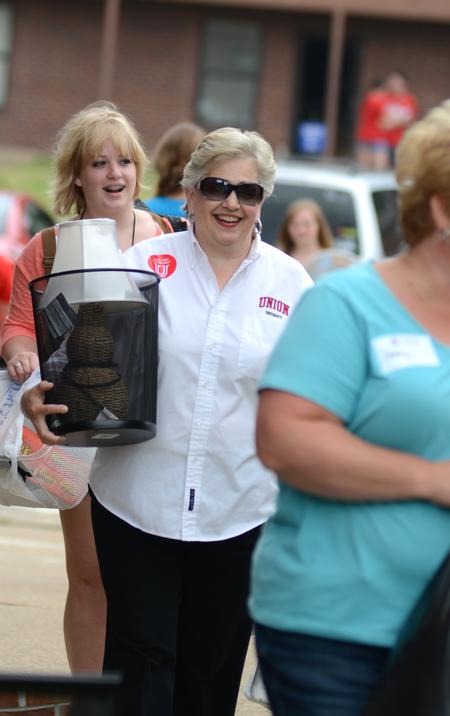 Lanese Dockery, first lady of the university, carries belongings to a Heritage Residence Complex room during new student move-in day. - Photo by Jacob Moore