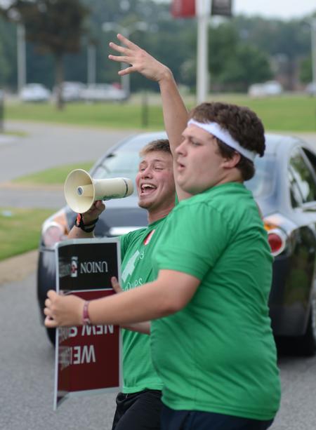 LifeGroup leaders Tim Zornes, junior elementary education major, and Doug May, junior music major, welcome new students and their families during new student move-in day. - Photo by Jacob Moore