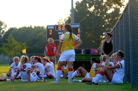 The women's soccer team rests during halftime of the exhibition game against Rhodes College. - Photo by Amanda Rohde