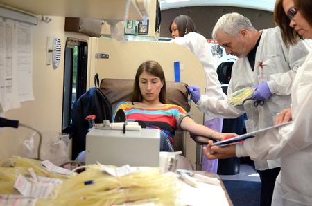 Lifeline employees prepare for freshman Audrey Mitchell to donate blood during the Lifeline Fall Blood Drive on campus. - Photo by Anne Richoux