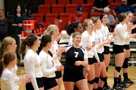 Lady Bulldog Elise Seufert throws a ball to the crowd as the volleyball team is introduced at the beginning of their game against Harding University. - Photo by Anne Richoux
