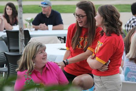 Shea Wingate, senior political science major, and Emily Pudlo, senior nursing major, talk with Wingate's mother at the Chi Omega barbecue fundraiser for Make a Wish Foundation. - Photo by Matt McDaniel