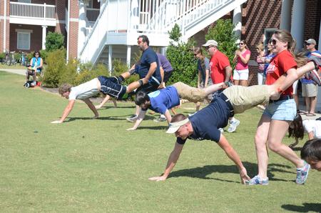 Students and their families participate in a wheelbarrow race during Family Olympics in the Grace quad.  - Photo by Anne Richoux