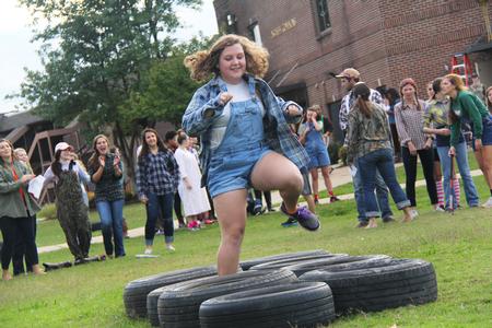 Tori Cagle, freshman Spanish education major, hops through the tires in the obstacle course during the DF Olympics in the Heritage Complex. - Photo by Matt McDaniel