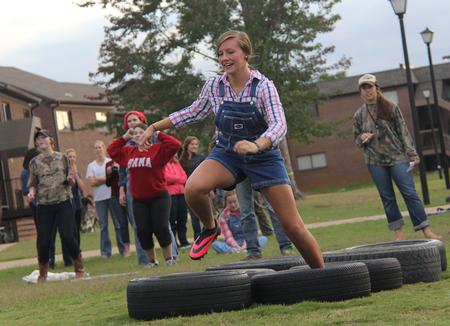 Morgan Marlar, freshman athletic training major, races through the tires in the obstacle course during the DF Olympics in the Heritage Complex. - Photo by Matt McDaniel