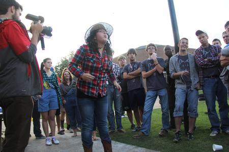Meghan Aranda, sophomore mathematics major, spits her cricket as far as she can in the cricket spitting competition during DF Olympics. - Photo by Matt McDaniel
