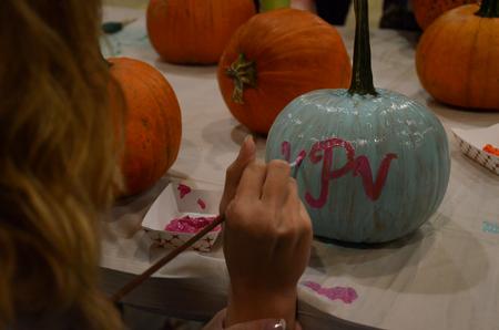Kaylene Portell, sophomore social work major, paints her initials onto a pumpking during the Casey Jones Hullabaloo hosted by the Student Activities Council.  - Photo by Anne Richoux