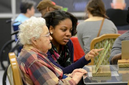 Angelica Shipps, freshman intercultural studies major, helps a resident play bingo at the Forest Cove Nursing and Rehabilitation Center during the 11th annual Campus and Community: A Day of Remembrance and Service. - Photo by Anne Richoux