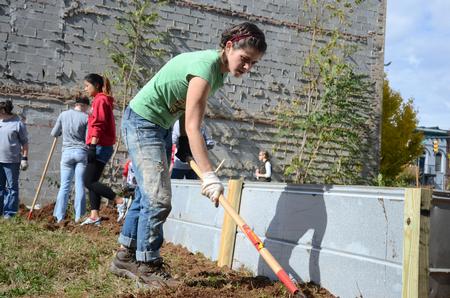 Ellen Cline, senior art major, works with other students on a garden in downtown Jackson for the Come Unity Cafe as a part of the 11th annual Campus and Community: A Day of Remembrance and Service.  - Photo by Anne Richoux