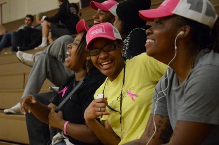 Students laugh together during a volleyball time-out in the Fred DeLay Gymnasium.  - Photo by Anne Richoux