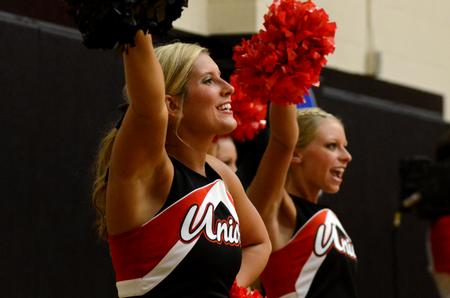 Kayla Dubrule, senior elementary education major, cheers for the basketball team as they play against Champion Baptist College in the Fred DeLay Gymnasium. - Photo by Anne Richoux