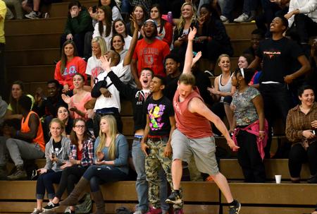 Students celebrate after Ashanti Day's dunk against Champion Baptist College in the Fred DeLay Gymnasium. - Photo by Anne Richoux