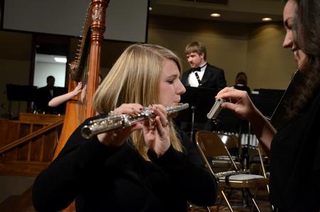Andrea Bolyard, sophomore music major, tunes her flute before the symphonic band concert at First Baptist Church.  - Photo by Anne Richoux
