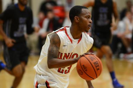 Corieon Pearson, junior business administration major, dribbles the ball past the defenders during the game against the Central Baptist College Mustangs. - Photo by Matt McDaniel