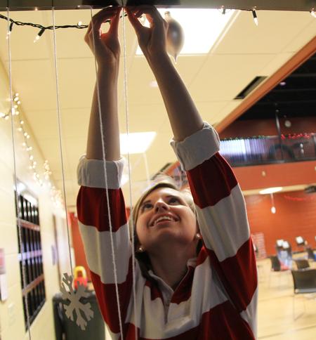 Jessica Vinyard, freshman mathematics major, hangs up Christmas decorations before the SAC Carl Perkins Christmas event in the Bowld Student Commons. - Photo by Matt McDaniel
