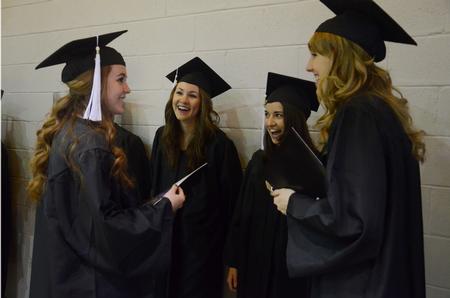 Graduates Jami Humphries, Courtney Hays, Carin Lachiver, and Olivia Wallace chat and laugh together before Fall Commencement Services at West Jackson Baptist Church.  - Photo by Anne Richoux