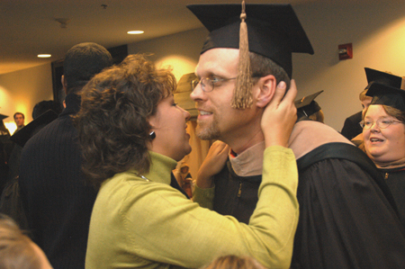 MBA Graduate Eric Arther received congratulations from his proud wife at fall graduation. - Photo by Jim Veneman