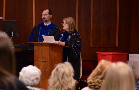 Sharon Evans, associate professor of nursing, tells new members about the history of the Alpha Chi honor society during the induction ceremony.  - Photo by Anne Richoux