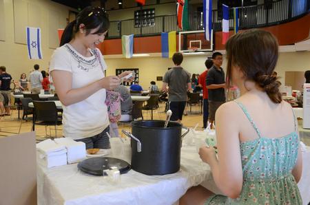 Sarah Paschall (right), sophomore computer science major, shares her Japanese treats with a visitor at the International Food Fair hosted by the International Students Union in the Bowld Student Commons. - Photo by MiKalla Cotton