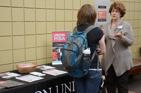 Luanne Powell, director of the MBA program, talks with a student about graduate degree options during the Graduate Degrees Informational Fair.  - Photo by MiKalla Cotton