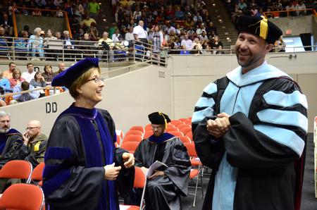 Cynthia P. Jayne, associate provost for intercultural and international studies, and Bryan L. Carrier, acting dean of students, chat proceeding the Spring Commencement Services at the Oman Arena. - Photo by MiKalla Cotton