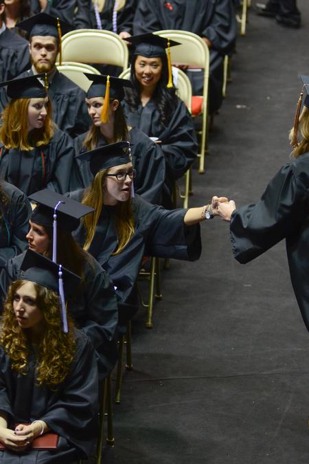 Shea Wingate, political science graduate, congratulates her friend, Ashley Smith, business administration graduate, on receiving her diploma at Spring Commencement Services. - Photo by Meg Rushing
