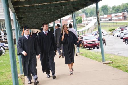 Undergraduate students make their way into Madison Academic High school to join their classmates before the Spring Commencement Services held at the Oman Arena. - Photo by Emily Stookey