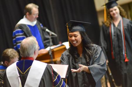 Alana Hu, public relations graduate, receives her diploma at Spring Commencement Services held at the Oman Arena. - Photo by Emily Stookey