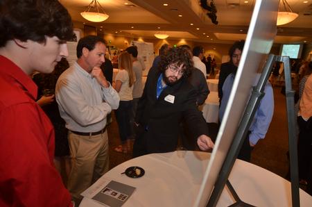 Physics  student Daniel Keylon  explains his research on his presentation board in the Grant Center. - Photo by Morris Abernathy
