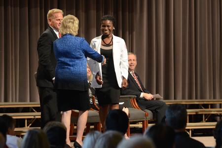 Ife Babatunde, pharmacy student, receives her white coat and shakes hands with Sheila Mitchell, dean of the School of Pharmacy, at the White Coat Ceremony. - Photo by MiKalla Cotton