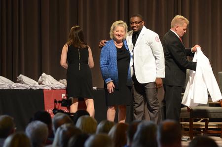 Rene Effoe, pharmacy student, poses with Sheila Mitchell, dean of the School of Pharmacy, after receiving his coat at the White Coat Ceremony in the G.M. Savage Memorial Chapel. - Photo by MiKalla Cotton