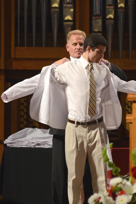 DJ Reynolds, class of 2018 pharmacy student, is presented his white coat at the White Coat Ceremony in the G.M. Savage Memorial Chapel. - Photo by Meg Rushing