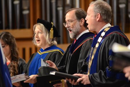 Jeannette Russ, professor of engineering and department chair, Hal Poe, faculty member of the year, and Dub Oliver, president of the university, sing "A Mighty Fortress Is Our God" at the beginning of Fall Convocation. - Photo by Emily Stookey