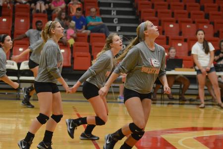 Elsie Seufert, Hannah Huguley and Kristin Cook move into position for the incoming volleyball at the alumni game in the Fred DeLay Gymnasium. - Photo by Emily Stookey