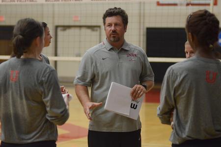 Tripp Swisher, head volleyball coach, gives the girls a pep talk before the start of the alumni game. - Photo by Emily Stookey