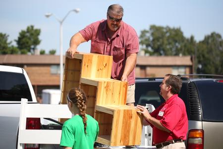 Jim Avery, associate vice president for information technology, helps the father of a new student move a shelf on new student move-in day. - Photo by Kristi McMurry Woody