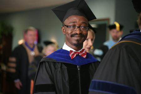 Richard Addo, associate professor of pharmaceutical sciences, processes into Convocation. - Photo by Kristi McMurry Woody