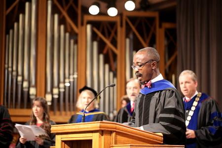 Richard Addo, associate professor of pharmaceutical sciences, reads scripture during Fall Convocation. - Photo by Kristi McMurry Woody