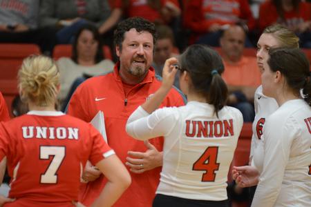 Tripp Swisher, head volleyball coach, talks with the team during a time out while they play Mississippi College in the Fred Delay Gymnasium. - Photo by Emily Stookey