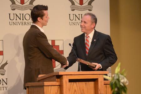 Barnabas Piper, head of Ministry Grid for LifeWay Christian Resources, presents Dub Oliver, president of the university, with a minister's Bible at the West Tennessee Pastors and Wives Appreciation Banquet. - Photo by Emily Stookey
