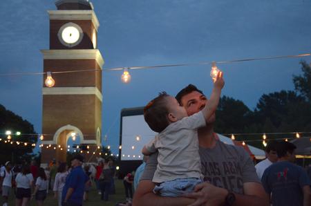 A toddler enjoys the lights and activities on the Great Lawn at Union Night during Family Weekend. - Photo by MiKalla Cotton