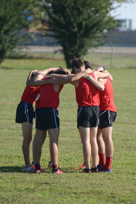 The men's cross country team gathers for a team prayer before a meet on Union University's campus. - Photo by Meg Rushing