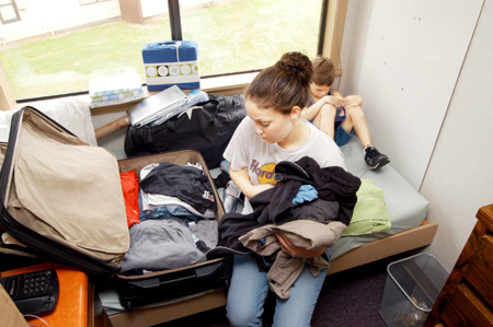 Freshman Julie Raynes, nursing major, began the daunting task of unpacking all her belongings into the confined space of her dormroom on Aug. 28, while younger brother, Kevin Raynes, played video games. - Photo by Kristen Hiller