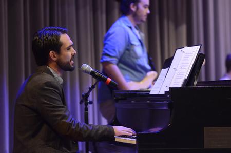 Cody Curtis, assistant resident director for the men's quads, leads students in a song during chapel.  - Photo by Emily Stookey